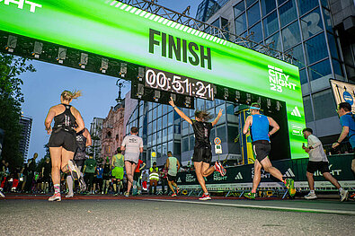 Runners running through the green lighted finish gate © SCC EVENTS / Tilo Wiedensohler