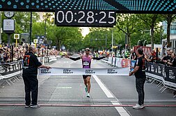 Hendrik Pfeiffer läuft über die Ziellinie der adidas Runners City Night 2025 und bricht den Streckenrekord