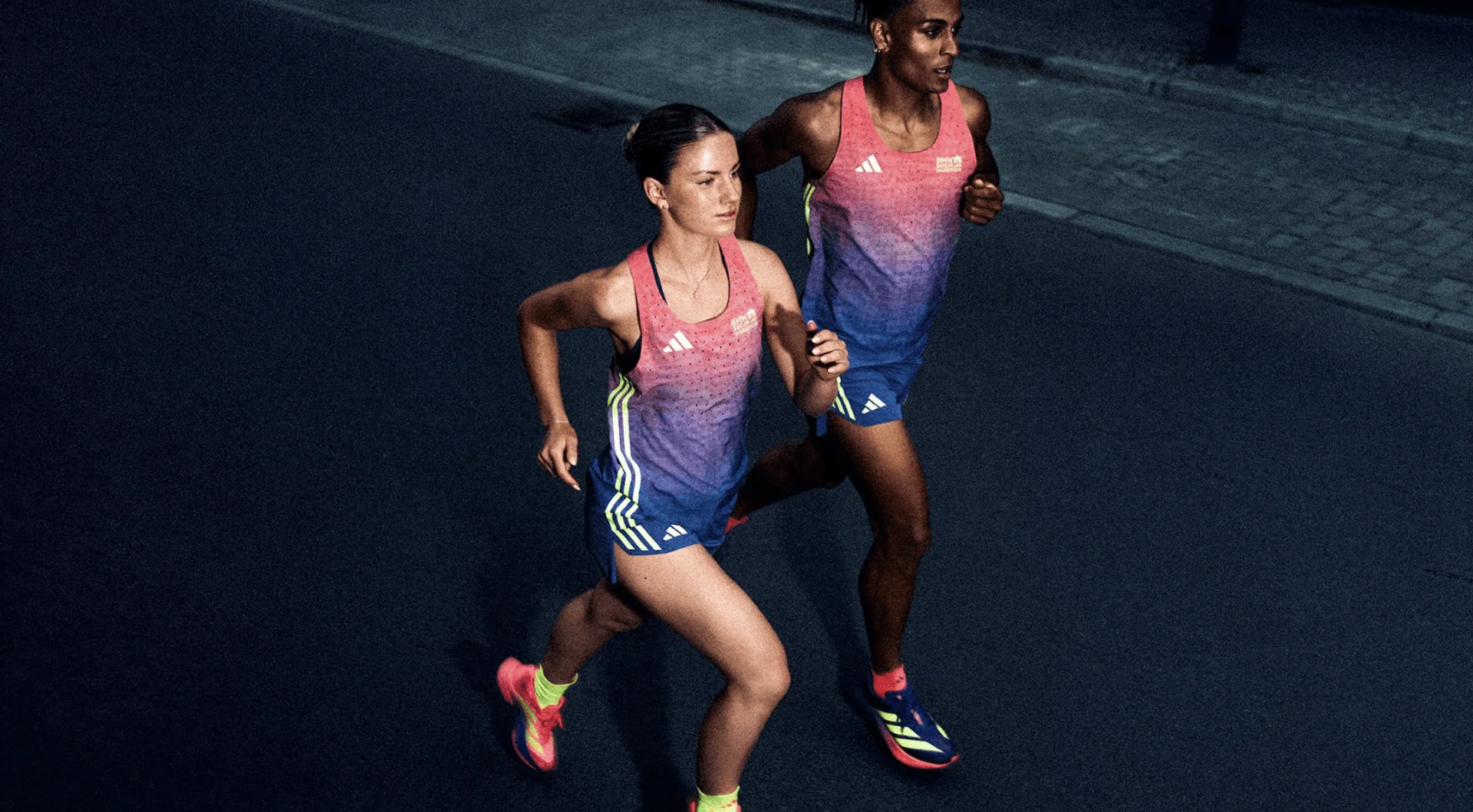 Two runners in the 2026 adidas Marathon Collection out for a jog at dusk.